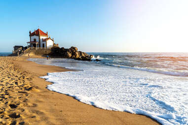 Capela do Senhor da Pedra chapel at sunset on Praia de Miramar, Portugal