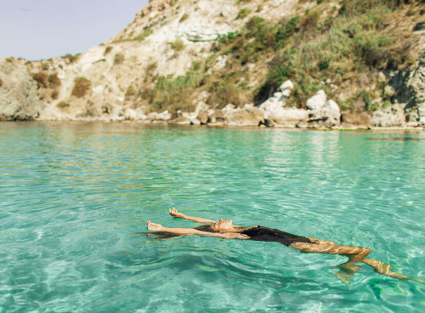 Woman in swimwear enjoying at beautiful turquoise colored water on tropical beach. 