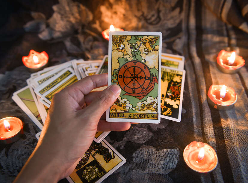 Hand holding tarot card with candlelight on the darkness background