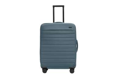 A medium sized cobalt blue Away soft-sided suitcase,