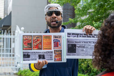 a tour guide holding up laminated documents and pictures
