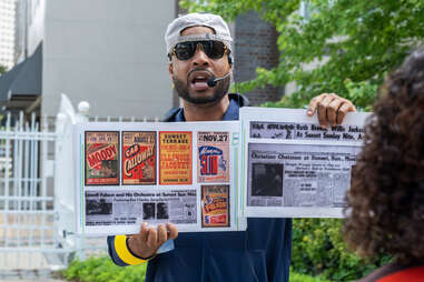 a tour guide holding up laminated documents and pictures 