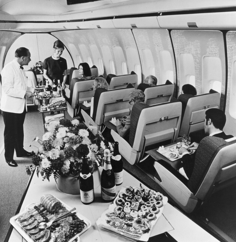 First class passengers in a BOAC Boeing 747 Jumbo Jet are served lunch.