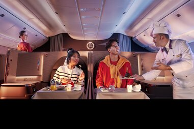 two people, a chef, and a flight attendant in Turkish Airways crystal business class seats