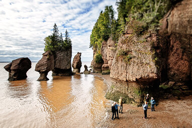 people standing next to dramatic rocks in Canada