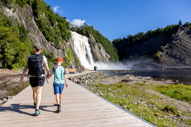 Mother and Son walking on the footbridge at Montmorency Falls in Summer, Quebec City, Canada