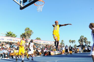 basketball player flying for a dunk at the venice beach basketball courts