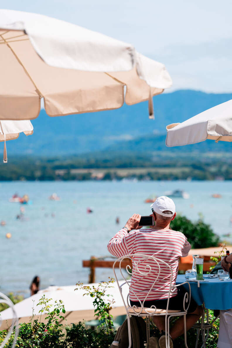 a man looking out onto a busy lake, taking pictures
