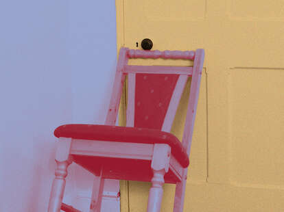 A graphic of a chair against a hotel room door.