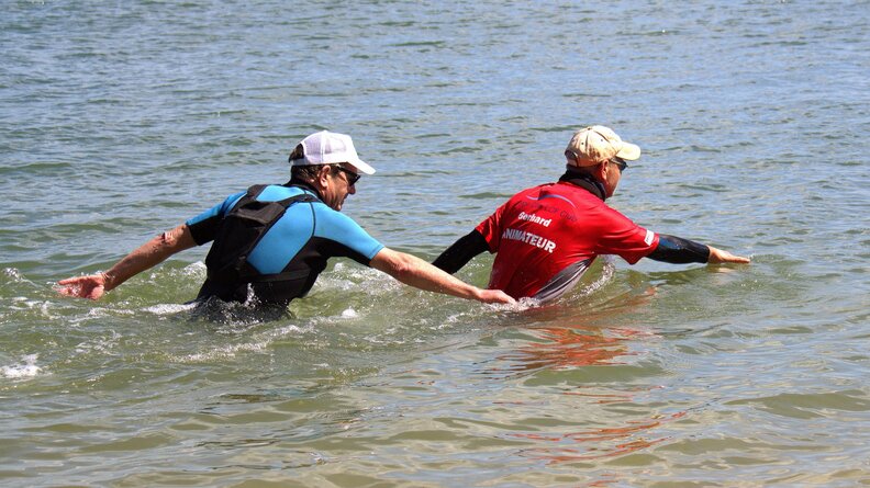 Two men sea wading, or aqua walking, walking in the water