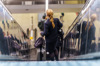 flight attendant in uniform at airport with bags