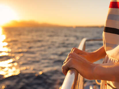 Closeup of female hands on a ship during sunset cruise breakups