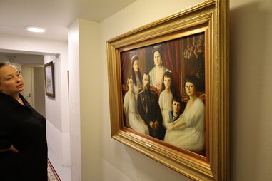 woman looking at russian painting in hallway
