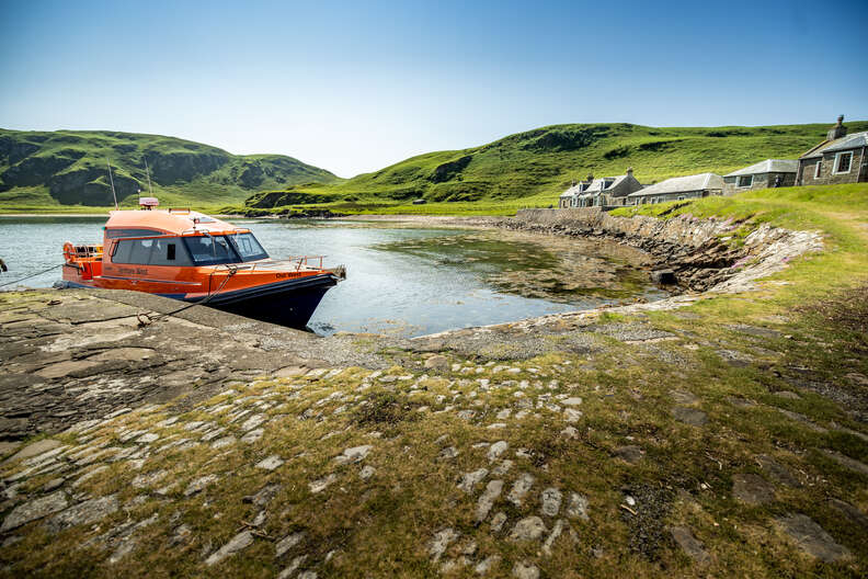 a red boat pulled up to an island 