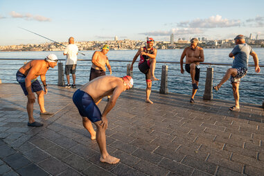 swimmers in caps stretching on boardwalk