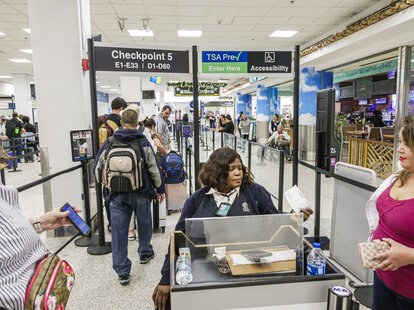 Miami International Airport security screening checkpoint with TSA Precheck and accessibility lanes.