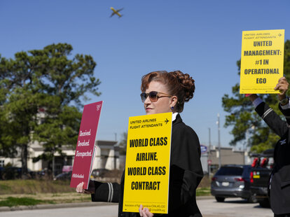 : Flight attendants from several airlines lined JFK Boulevard near George Bush Intercontinental Airport picketing for fair contract negotiations, holding signs.