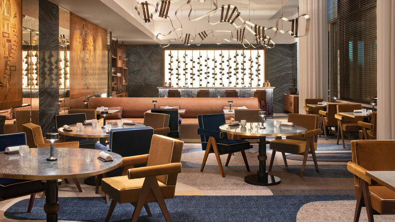 a restaurant with velvet chairs and gold decor