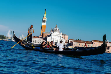 group of tourists share a gondola ride in Venice