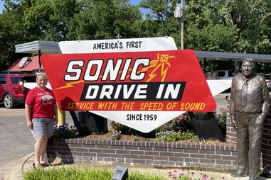 crissy mcentire posing in front of the original sonic drive-in in stillwater, oklahoma
