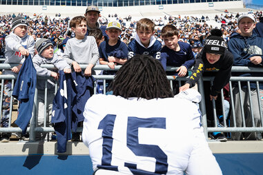 Amin Vanover #15 signs autographs for fans during the Penn State Spring Football Game at Beaver Stadium on April 13, 2024 in State College, Pennsylvania