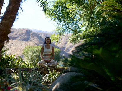 woman doing yoga in the foliage at sensei porcupine creek in coachella valley