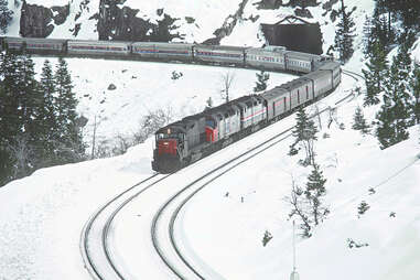 two amtrak trains in the snow in the donner pass at yuba pass, california