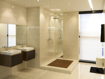 Modern and spacious bathroom that does not have walls around the shower.
