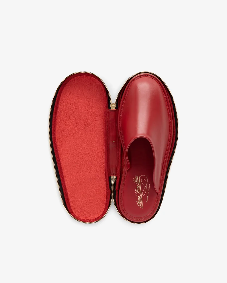 A red leather travel slipper inside of a zippered pouched the exact same shape.