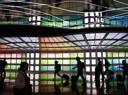 People walk the ‘Terminal for Tomorrow’ neons at the O’Hare International Airport in Chicago, United States on October 19, 2022