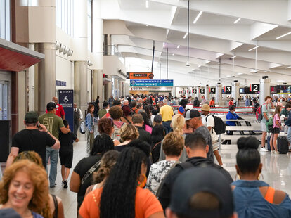 ATLANTA, GEORGIA - JULY 20: People wait in line at Hartsfield-Jackson Atlanta International Airport on July 20, 2024 in Atlanta, Georgia.