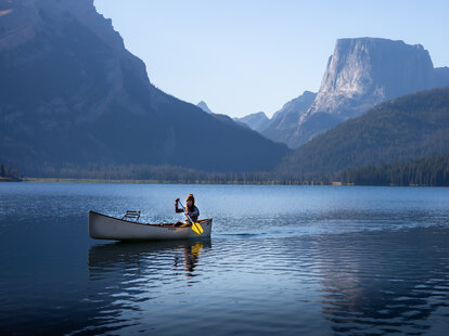 Woman canoeing by herself on a lake in Wyoming