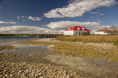 white building with red roof by the water