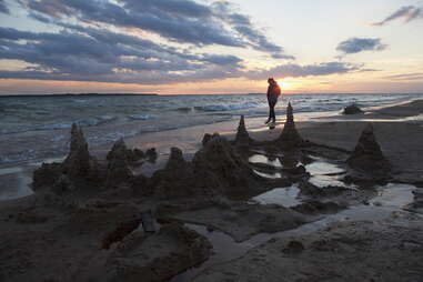 person walking on beach during sunset alone 