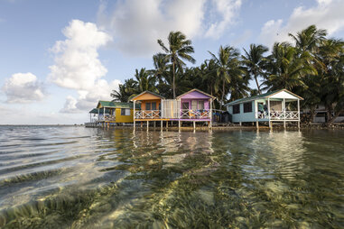 Tobacco Caye, Belize, houses on stilts in the water by an island