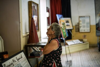 a woman looking at historic displays in a schoolhouse
