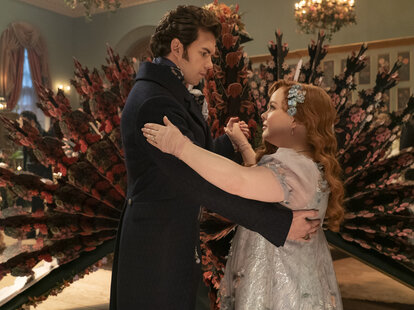 Two characters from the Netflix show Bridgerton dancing at a ball
