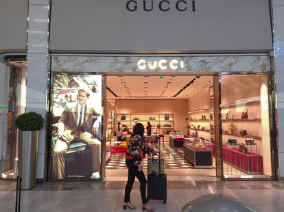 A vwoman walks past a Gucci butique shop located at Paris Charles de Gaulle Airport, on August 14, 2023, in France.