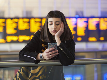 Woman checks phone after traveling