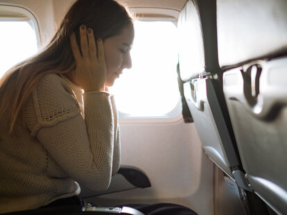 Woman Suffering From Ear Pain In Airplane