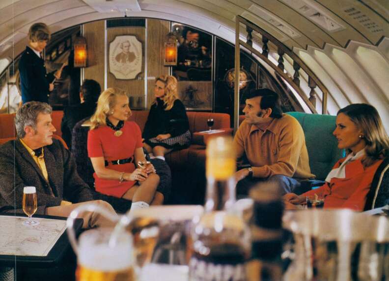 people sitting in a lounge on an airplane that is mostly orange