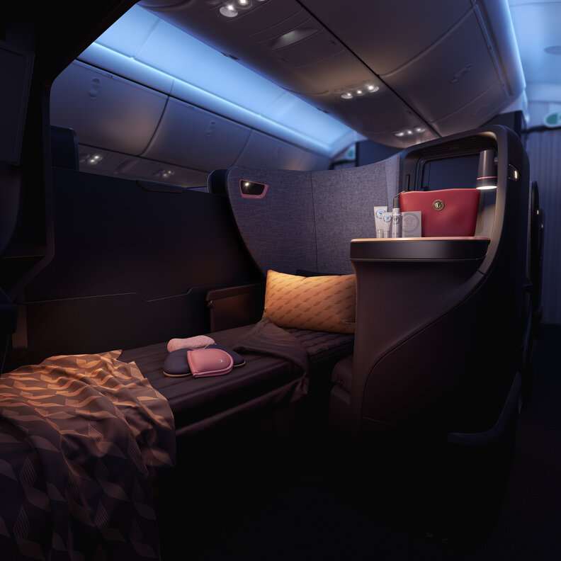 a lie-flat chair on an airline set up with linens