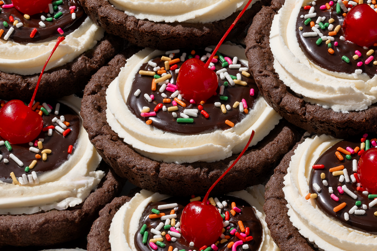 A close up shot of Crumble Cookies with cherries on top. 