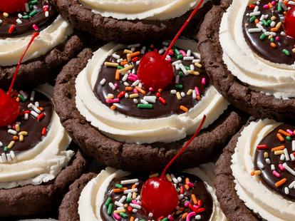 A close up shot of Crumble Cookies with cherries on top.