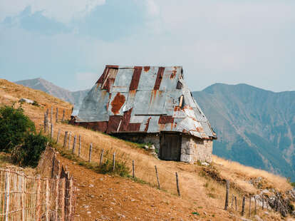 house with tin roof at entrance to lukomir bosnia