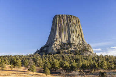 a large monolith rising from the ground; devil's tower