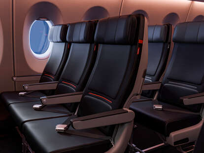 Main cabin seating in Delta with the new seat design which features darker engineered leather and warm mood lighting.