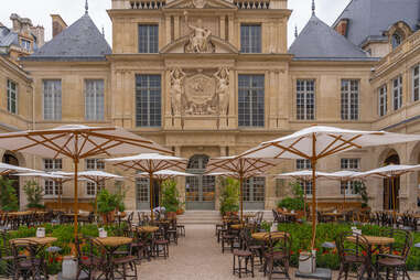 Musée Carnavalet facade with patio chairs and umbrellas