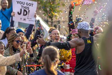 Members of the Harlem Runners pop confetti for a marathon runner