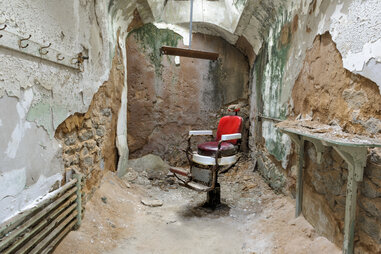 a red chair in crumbling surroundings